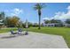 An open backyard with a patio set on the concrete, green grass, and some trees in sight at 2434 Carlisle Pl, Sarasota, FL 34231