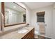 Well-lit bathroom featuring a granite vanity, a decorative mirror, and tile flooring at 2434 Carlisle Pl, Sarasota, FL 34231