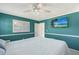 Bedroom with teal-blue walls, white trim and a flat-screen television mounted on the wall at 2434 Carlisle Pl, Sarasota, FL 34231