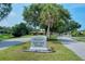 Welcome to Gulf Gate Woods neighborhood sign surrounded by lush landscaping and mature trees on a sunny day at 2434 Carlisle Pl, Sarasota, FL 34231