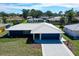A well-maintained home features a pristine grey tile roof, vibrant blue exterior and manicured lawn at 2434 Carlisle Pl, Sarasota, FL 34231