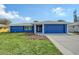 Charming one-story home featuring a well-manicured lawn and a blue exterior paint scheme with matching garage door at 2434 Carlisle Pl, Sarasota, FL 34231