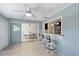 Bright Florida room featuring a bar with seating, wood-look floors, and sliding door access to the dining area at 2434 Carlisle Pl, Sarasota, FL 34231