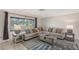 Inviting living room with a large sectional sofa, area rug, and plenty of natural light at 2434 Carlisle Pl, Sarasota, FL 34231