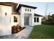 Striking front entry with a geometric walkway, modern light fixtures, and a sleek, light-blue double-door at 2760 Adele St, North Port, FL 34291