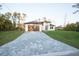 Exterior elevation view of the home featuring a paved driveway, two-car garage and manicured lawn at 2760 Adele St, North Port, FL 34291