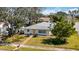 Charming single-story home with a manicured front lawn, mature trees, brick walkway, and bright yellow front door at 317 Harbor S Dr, Venice, FL 34285