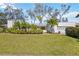 Charming home featuring a well-manicured lawn and lush landscaping with mature trees and vibrant greenery at 317 Harbor S Dr, Venice, FL 34285