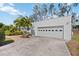 Two-car garage with white exterior and decorative window cutouts with landscaping at 317 Harbor S Dr, Venice, FL 34285