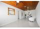 Bright living room with polished tile floor and a distinctive wood plank ceiling with ceiling fan at 317 Harbor S Dr, Venice, FL 34285