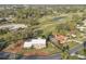Aerial view of home on golf course with a screened in pool, mature trees, and an ample lawn at 3215 Pine Valley Dr, Sarasota, FL 34239