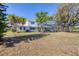 A spacious backyard featuring a screened-in pool area and mature trees providing shade and privacy at 3215 Pine Valley Dr, Sarasota, FL 34239