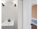 Clean bathroom with a modern vanity, decorative sconces, and partial view of patterned wallpaper at 3215 Pine Valley Dr, Sarasota, FL 34239