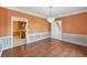 Formal dining room showcasing hard wood floor, chair rail, chandelier and view to kitchen at 3215 Pine Valley Dr, Sarasota, FL 34239