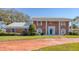 Stunning brick home featuring a blue front door, symmetrical windows, and a spacious front yard at 3215 Pine Valley Dr, Sarasota, FL 34239