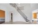 Spacious foyer featuring a curved staircase with decorative iron railings and tile flooring at 3215 Pine Valley Dr, Sarasota, FL 34239