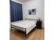 Cozy bedroom with a metal bed frame, wooden flooring, and a bedside table with decor at 3650 S Sumter Blvd, North Port, FL 34287
