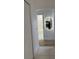 Hallway view with a decorative mirror and a glimpse into the bathroom and kitchen areas at 3650 S Sumter Blvd, North Port, FL 34287