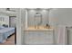 Bathroom vanity with white cabinets, framed mirror, and neutral-toned countertop at 3933 Glen Oaks Manor Dr, Sarasota, FL 34232