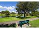 Scenic view of the community lake with a bench, lush greenery, and a tranquil atmosphere at 3933 Glen Oaks Manor Dr, Sarasota, FL 34232