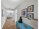 Inviting hallway with stylish décor, beautiful wall art, and elegant wood-look flooring, leading to a bright living area at 3933 Glen Oaks Manor Dr, Sarasota, FL 34232