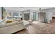 Bright living room with wood floors, white sofa, and large sliding glass doors at 3933 Glen Oaks Manor Dr, Sarasota, FL 34232