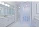 Modern bathroom with dual vanities, tile accent wall, and a separate walk-in shower at 501 Tamiami N Trl # 601, Venice, FL 34285