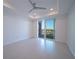 Bright bedroom with recessed lighting, tray ceiling, and sliding glass doors leading to a balcony at 501 Tamiami N Trl # 601, Venice, FL 34285
