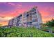 Beautiful condo building with sunset, balconies, landscaping, and luxurious architectural features at 501 Tamiami N Trl # 601, Venice, FL 34285