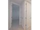 Hallway leading to a bedroom featuring light wood floors and neutral decor at 501 Tamiami N Trl # 601, Venice, FL 34285