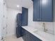 Laundry room featuring a stackable washer and dryer, quartz countertops, and custom cabinets at 501 Tamiami N Trl # 601, Venice, FL 34285