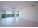 An airy living room with floor-to-ceiling glass doors showcasing waterfront views and a modern ceiling fan at 501 Tamiami N Trl # 601, Venice, FL 34285