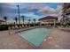 Relaxing community pool surrounded by palm trees, lounge chairs and covered seating areas for residents' enjoyment at 501 Tamiami N Trl # 601, Venice, FL 34285