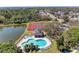 Aerial view of community pool, clubhouse, and tennis courts nestled amongst lush landscaping and a tranquil pond at 5103 73Rd E St, Bradenton, FL 34203