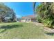 Expansive backyard with well-maintained lawn, tropical landscaping, and screened-in patio off of home at 5103 73Rd E St, Bradenton, FL 34203