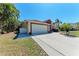 Inviting home showcasing a well-manicured lawn, palm trees, and a convenient two-car garage at 5103 73Rd E St, Bradenton, FL 34203