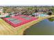 Aerial view of tennis courts, pool, and clubhouse, bordered by a tranquil pond at 5103 73Rd E St, Bradenton, FL 34203