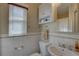 Compact bathroom with a toilet, sink, overhead cabinet, and a window for natural light at 511 74Th N Ave, St Petersburg, FL 33702