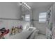Bright bathroom with white tile, a mirrored cabinet, and a shower with a floral curtain at 511 74Th N Ave, St Petersburg, FL 33702