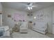 Bright Bedroom featuring a white crib, comfortable chair, and charming decor for a welcoming space at 511 74Th N Ave, St Petersburg, FL 33702