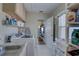 Functional laundry room with washer, dryer, sink, shelving and backyard access through an adjacent room at 511 74Th N Ave, St Petersburg, FL 33702