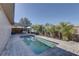 Full view of the backyard in-ground pool featuring a brick paver deck, covered patio and lush landscaping at 511 74Th N Ave, St Petersburg, FL 33702
