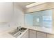 View of a stainless steel kitchen sink and countertop into the open-concept living area at 5400 Gulf Dr # 35, Holmes Beach, FL 34217