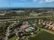 Aerial view showcasing the community's clubhouse, pool, tennis courts, playground, and lush landscaping at 5656 Cantucci St, Nokomis, FL 34275