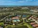 Aerial view of the community clubhouse, pool, tennis courts, playground and surrounding landscaping at 5656 Cantucci St, Nokomis, FL 34275