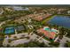 An aerial view of the community featuring the pool, tennis courts, clubhouse, and waterfront property at 5656 Cantucci St, Nokomis, FL 34275