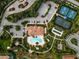 Aerial view of community clubhouse with pool, tennis courts, parking, playground, and lush landscaping at 5656 Cantucci St, Nokomis, FL 34275