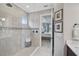 Bright bathroom with a glass enclosed shower, tiled walls, and view into the bedroom from the bathroom doorway at 5656 Cantucci St, Nokomis, FL 34275