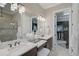 Bathroom featuring double sinks with marble countertops and a vanity, along with a walk-in closet at 5656 Cantucci St, Nokomis, FL 34275