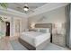 A well-lit bedroom features a neutral color palette, complementing the crown molding, ceiling fan, and light hardwood flooring at 5656 Cantucci St, Nokomis, FL 34275